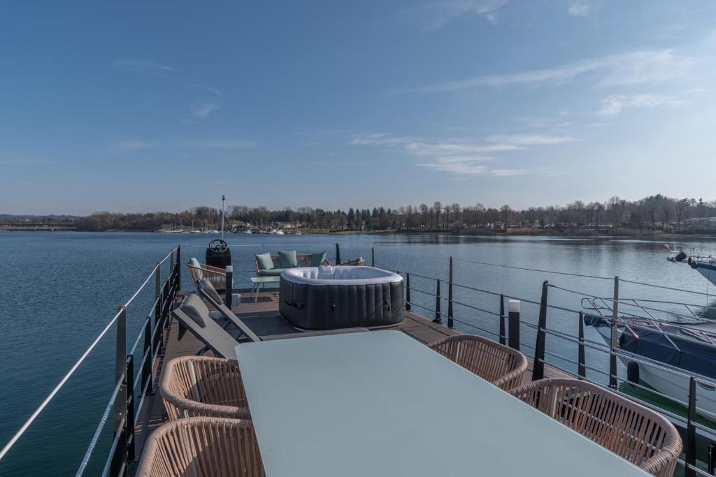 a boat with a table and chairs on the water at La Dolce Vita House Boat in Lisanza