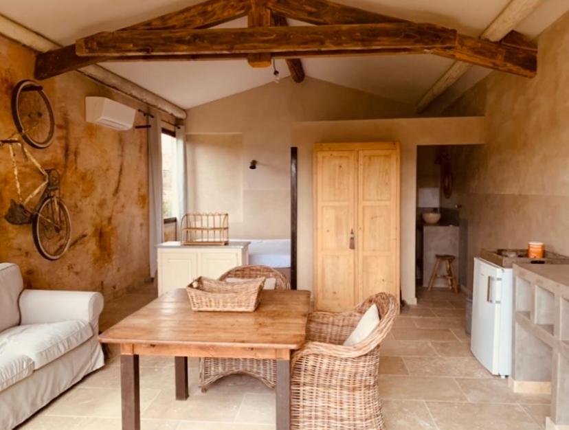 a living room with a wooden table and chairs at Le Vieux Portail in Saint-Saturnin-lès-Apt