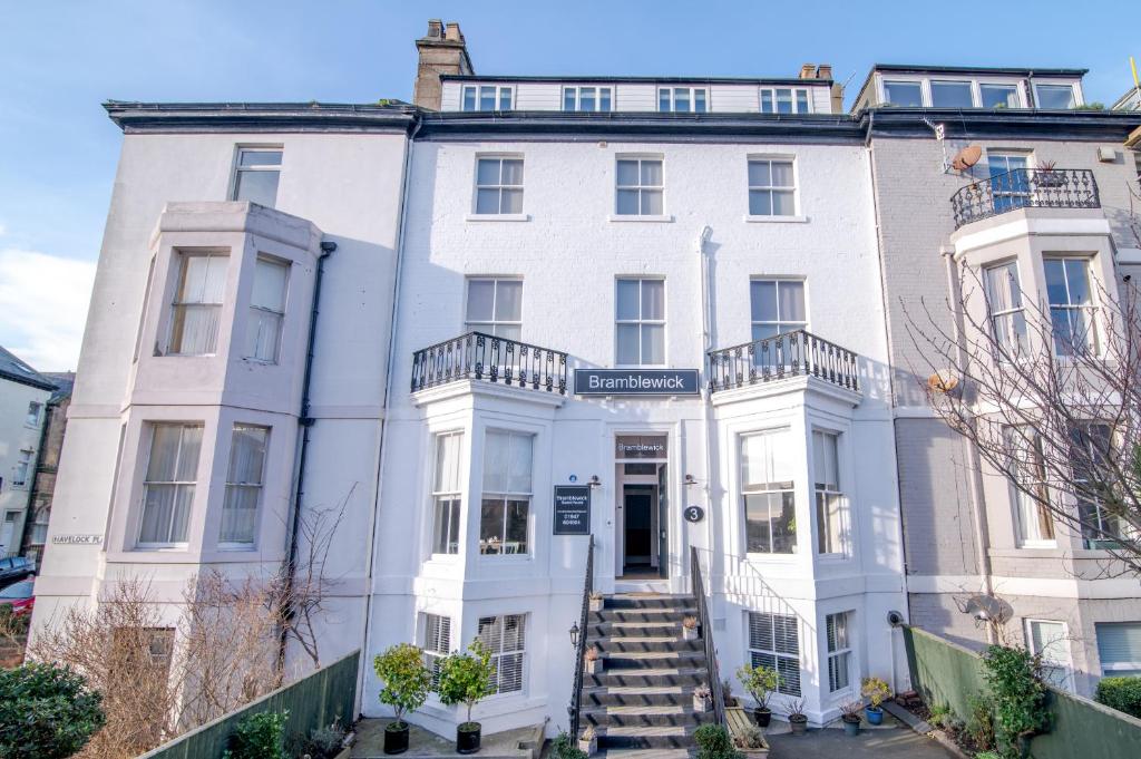 a white house with a staircase in front of it at Bramblewick in Whitby