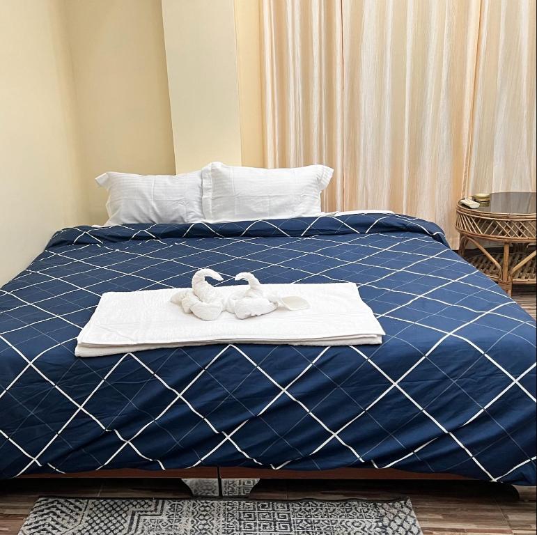 Iranyai Homestay في امفال: سرير ازرق وفوط بيضاء عليه