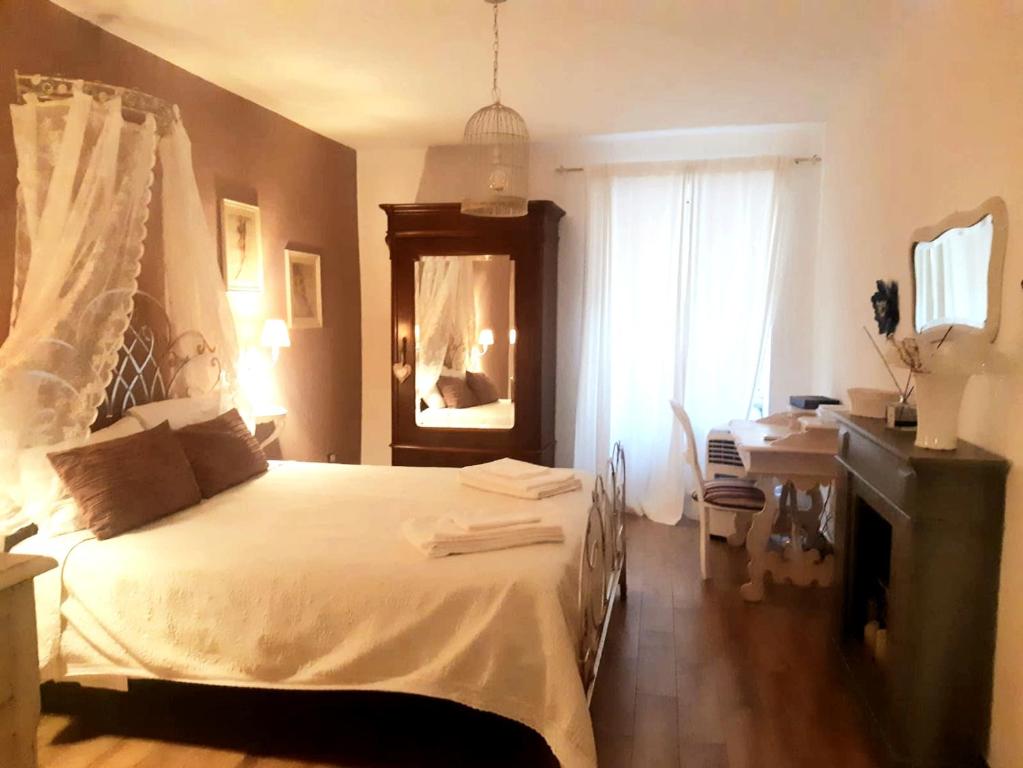 Schlafzimmer mit einem Bett, einem Schreibtisch und einem Spiegel in der Unterkunft Livia s Charming House in Trevignano Romano