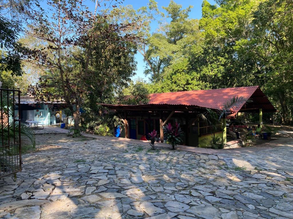 een klein gebouw met een rood dak op een stenen weg bij Hostal Paraíso Teenek Tambaque 