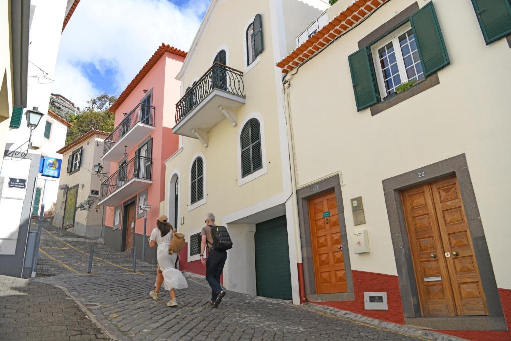 Un groupe de personnes marchant dans une rue dans l'établissement Alojamento Príncipe D.Luís, à Ponta do Sol