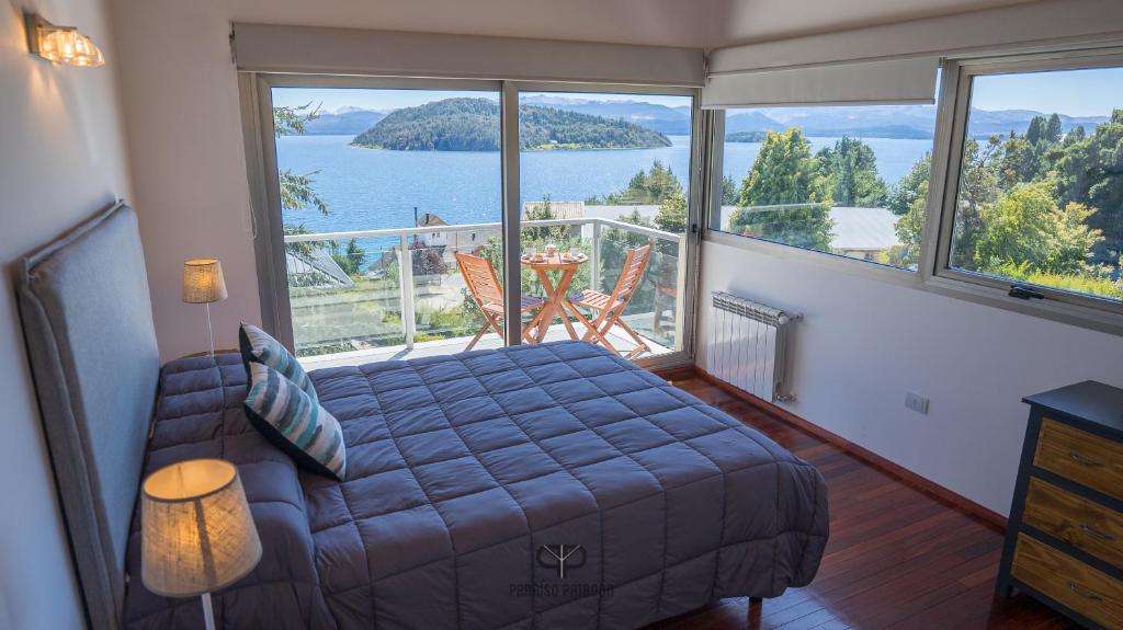 a room with a bed and a balcony with a view at Departamento con Vista Panorámica al Lago in San Carlos de Bariloche