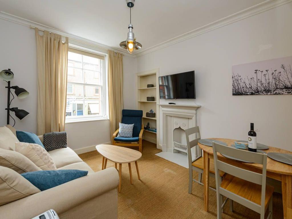 a living room with a couch and a table at Pebbles Apartment in North Berwick