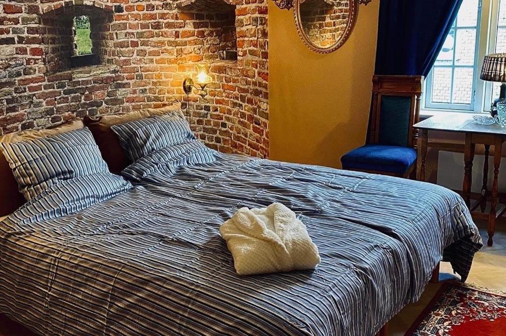 a bed in a bedroom with a brick wall at Skuespiller Centralen in Viborg