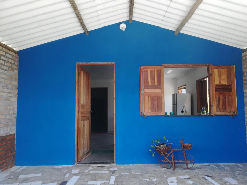 - un mur bleu avec un miroir dans la chambre dans l'établissement Chalet Vida de Roça, à Ibicoara