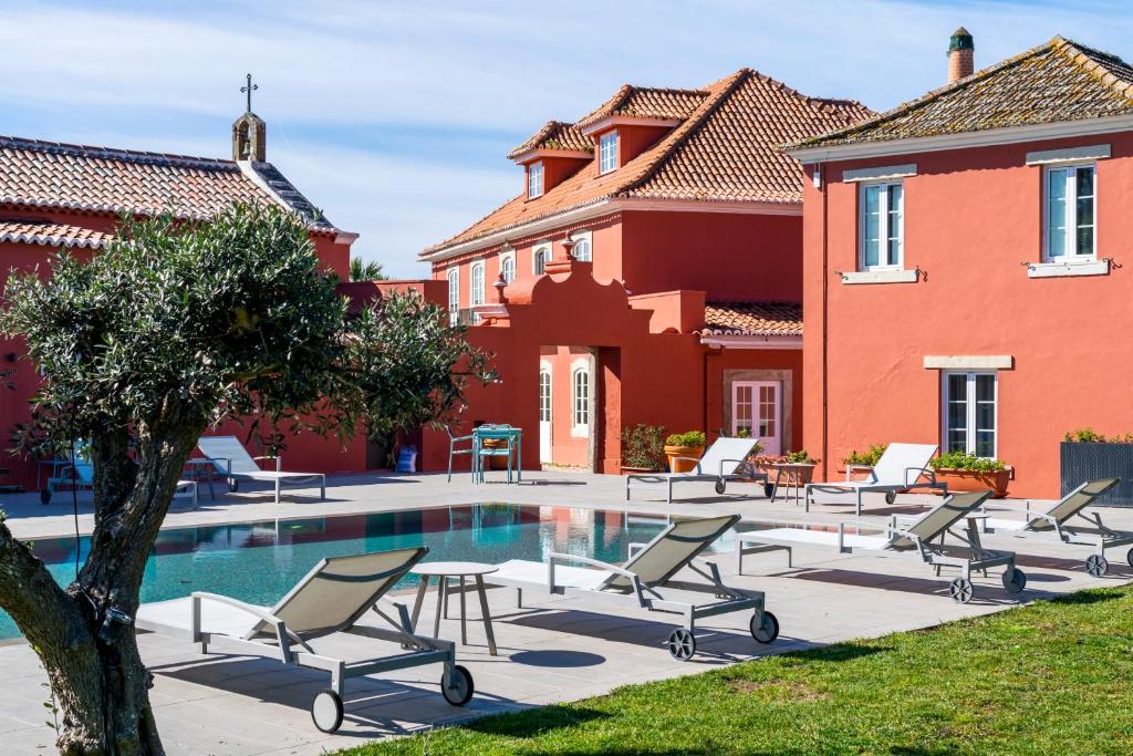 a courtyard with chairs and a pool in front of a house at Paço do Bispo Boutique House in Sintra