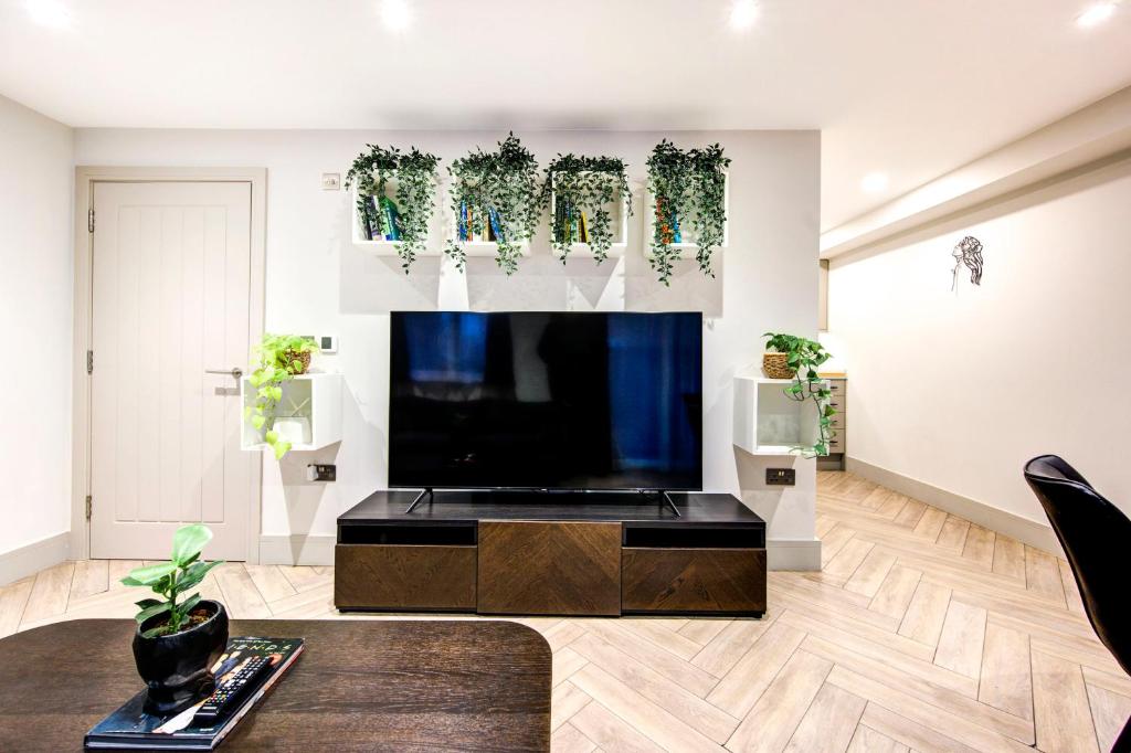 a living room with a large flat screen tv at Lovely 1-bed flat with a balcony & garden access in London