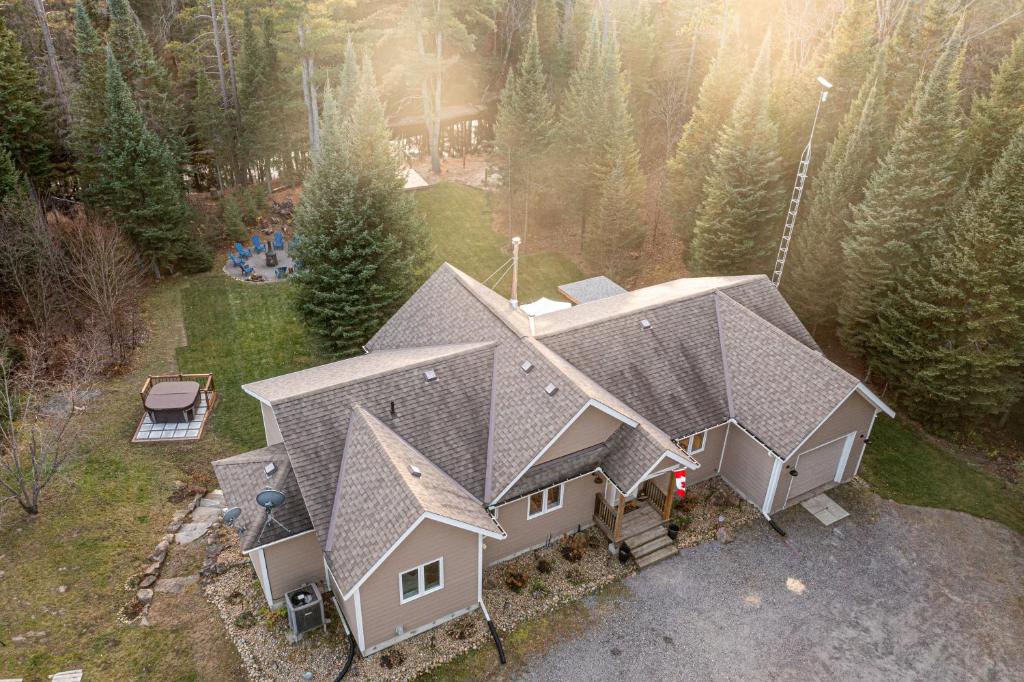 an aerial view of a house in the woods at Waterfront Muskoka Cottage with Hot Tub & Game Room in Bracebridge
