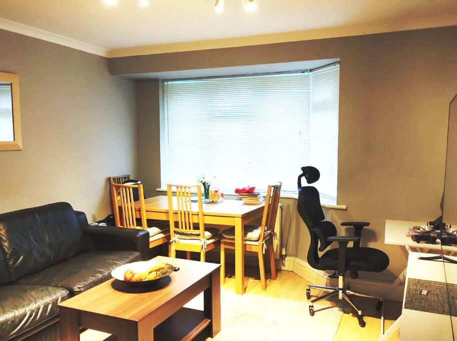 a living room with a couch and a table and a dining room at 2 Bed Flat Near Station with Parking&Comgarden in Sutton