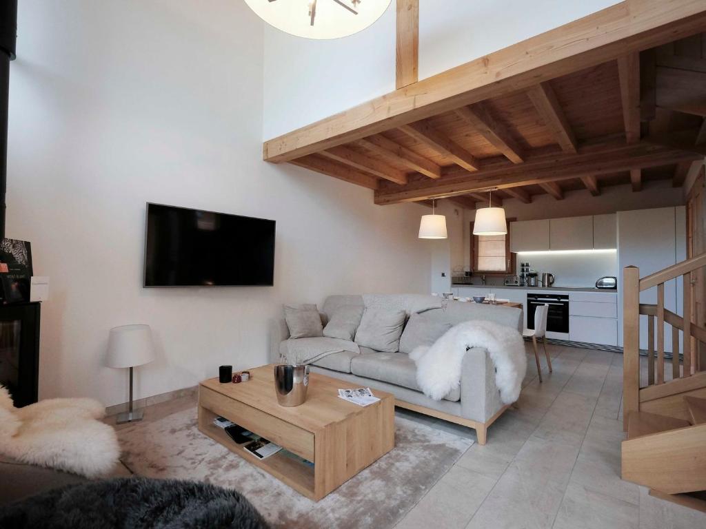 un salon avec un canapé et une table dans l'établissement Chalet Aigle · Accès Pistes · Wifi · Jacuzzi · Sauna · Poêle à bois · Parking · 3 Chambres en Suite - FR-1-344-804, à Saint-Martin-de-Belleville
