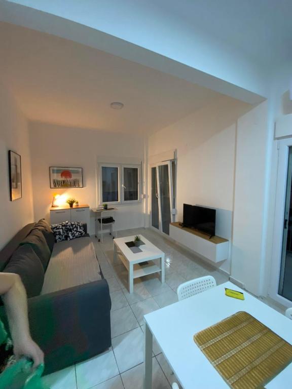 a living room with a couch and a table at Sunny Peraia Apartment in Perea