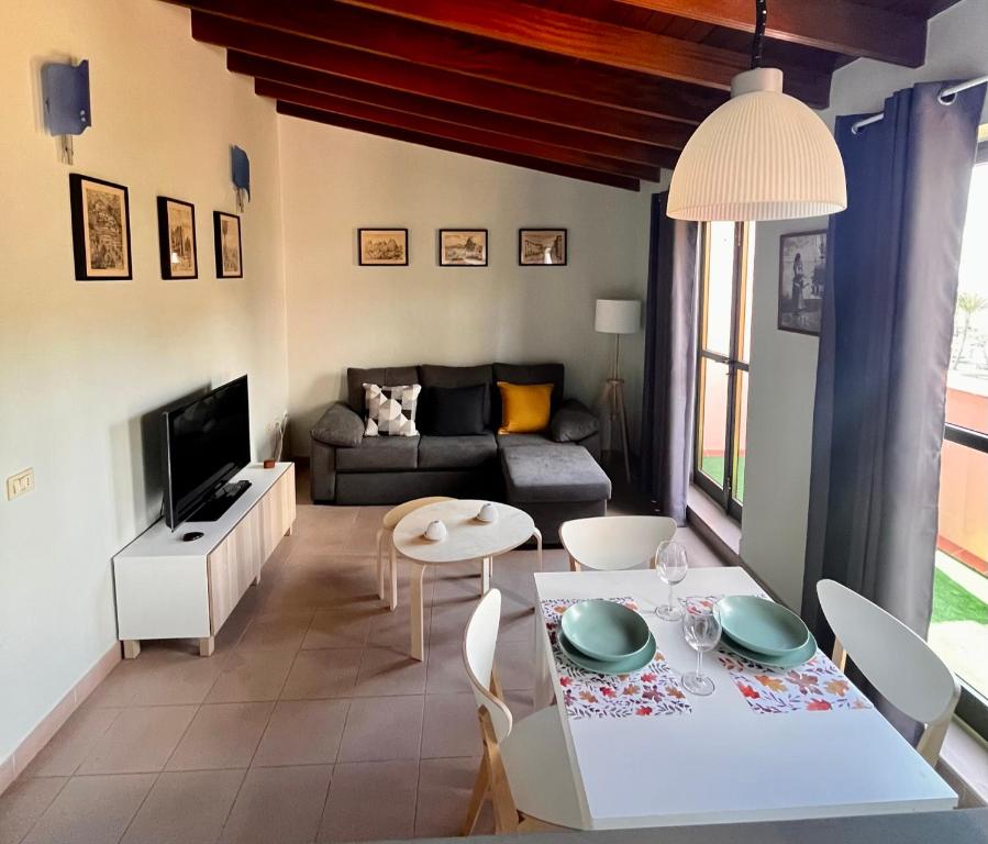 a living room with a couch and a table and chairs at Ático Parque in San Sebastián de la Gomera