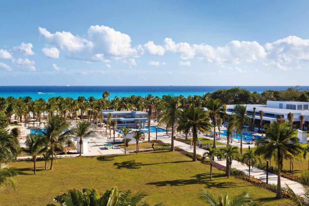 una vista aérea de un complejo con palmeras y el océano en Riu Palace Mexico - All Inclusive en Playa del Carmen