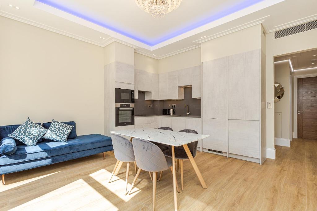 a living room with a blue couch and a table at LuxLet Apartments - Heart of Hampstead, London in London