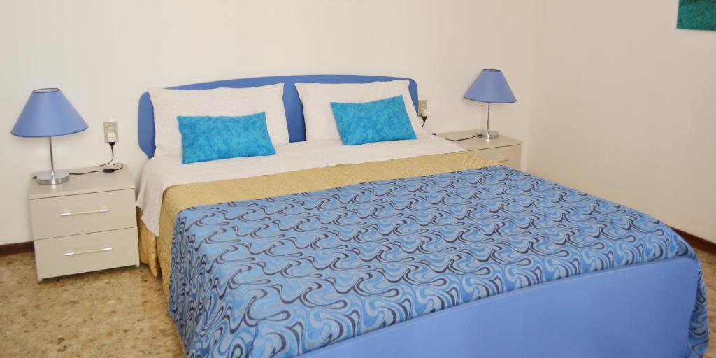 Un dormitorio con una cama azul y blanca con almohadas azules en Da Virginia B&B, en Verona