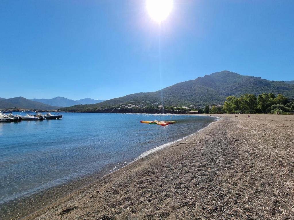 una playa con un barco en el agua en Résidence Palmarella, en Galeria