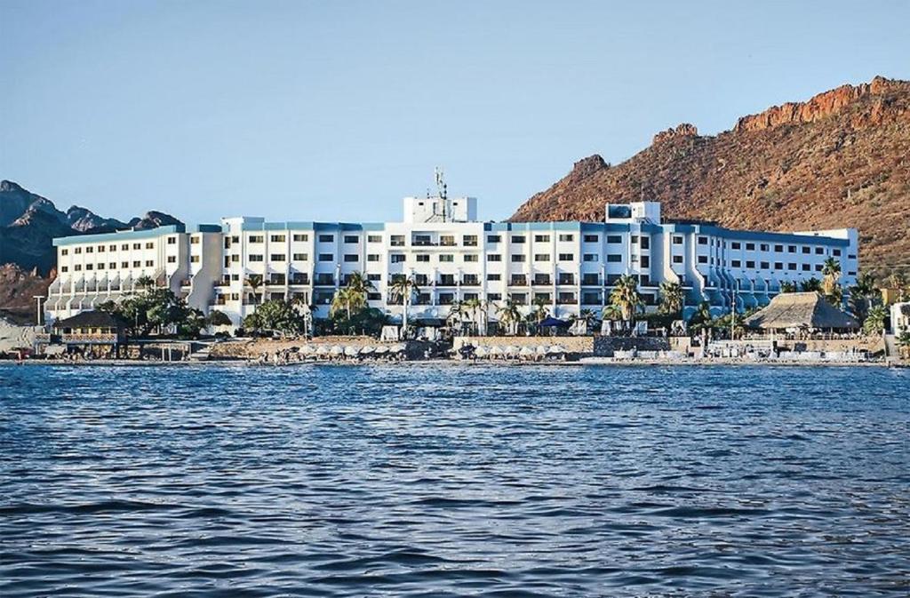 a large white building on the shore of a body of water at HOTEL SAN CARLOS PLAZA in San Carlos