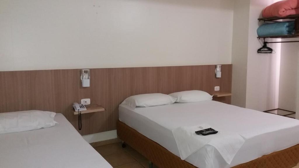una camera d'albergo con due letti e un telefono di Hotel Romanville a Chapecó