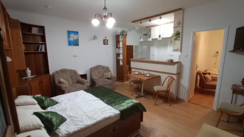 Schlafzimmer mit einem Bett, einem Tisch und Stühlen in der Unterkunft Londira Apartman Hévíz in Hévíz