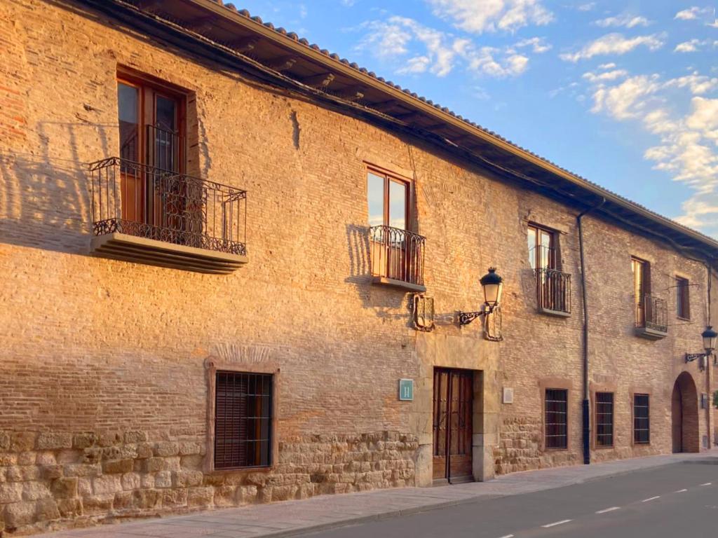 a brick building with windows and balconies on a street at Hostal El Palacio in Valencia de Don Juan