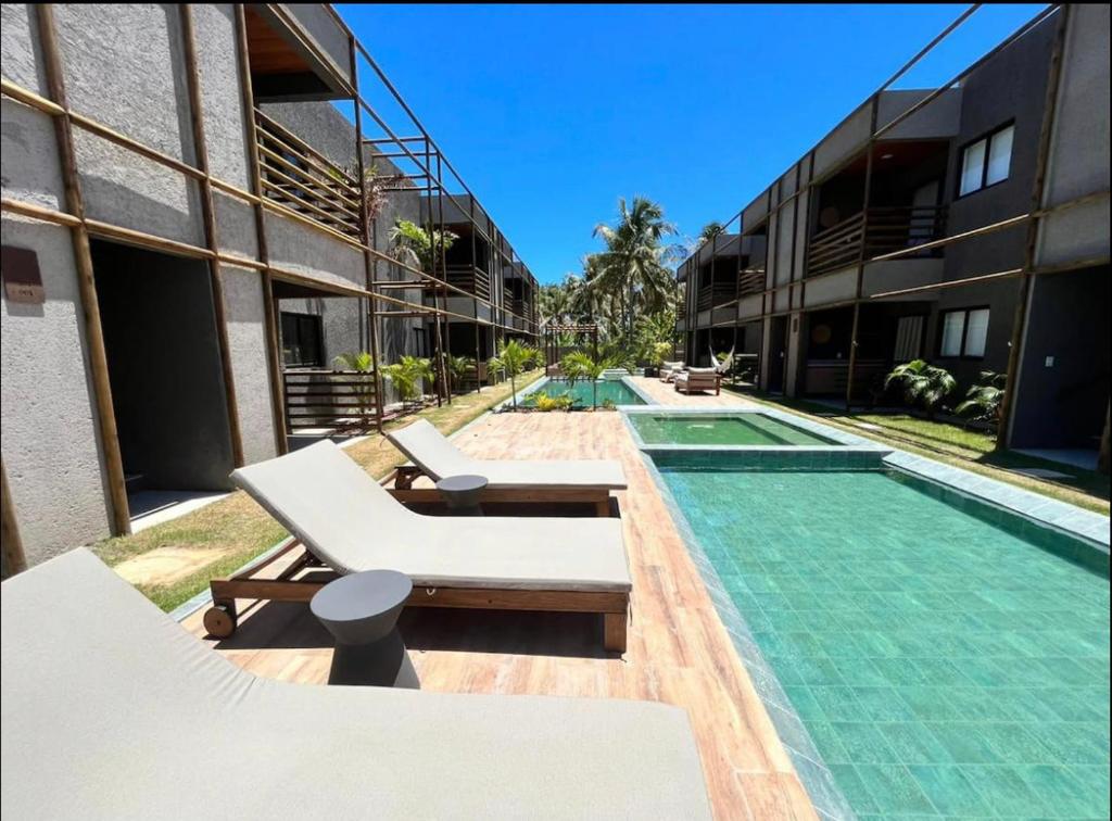 圣米格尔-杜斯米拉格里斯Villa Kamby 103B的一座游泳池旁设有两把躺椅