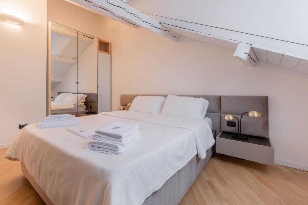 ミラノにあるBrera Flat Near Duomoのベッドルーム(鏡付きの大きな白いベッド1台付)