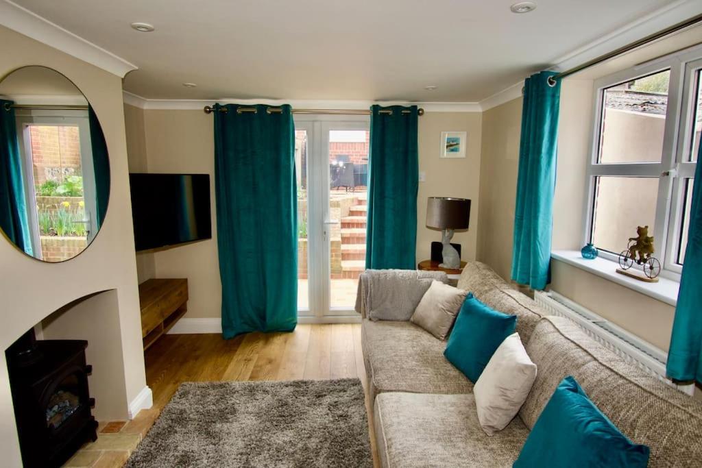 uma sala de estar com cortinas azuis e um sofá em Cottage in Framlingham em Framlingham