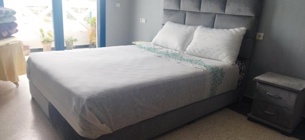 a bedroom with a large bed with white sheets and pillows at Lovers & Surfers Room - 5 min To Beach in Essaouira