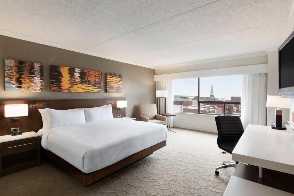 a hotel room with a bed and a large window at Delta Hotels by Marriott Saint John in Saint John