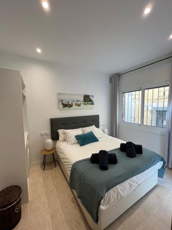 um quarto com uma cama grande e uma janela em Apartamento St Zenon em Arenys de Mar