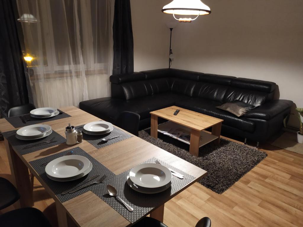 uma sala de estar com um sofá de couro preto e uma mesa em Rodinný apartmán Nová Seninka em Staré Mesto