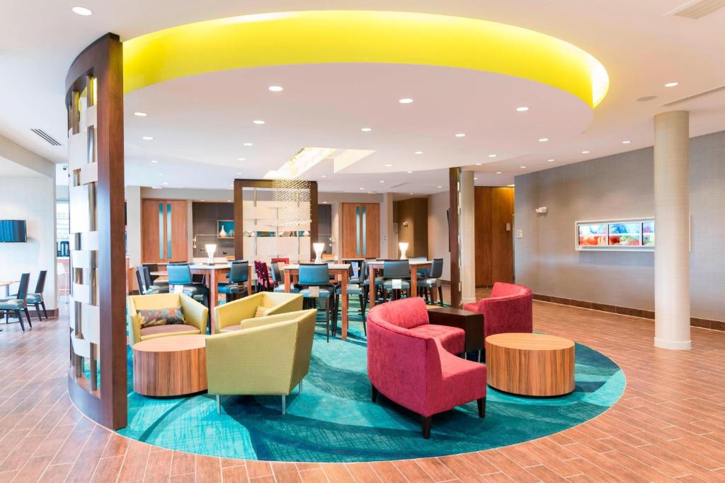 a lobby of a hotel with colorful chairs and tables at SpringHill Suites by Marriott Chicago Southeast/Munster, IN in Munster