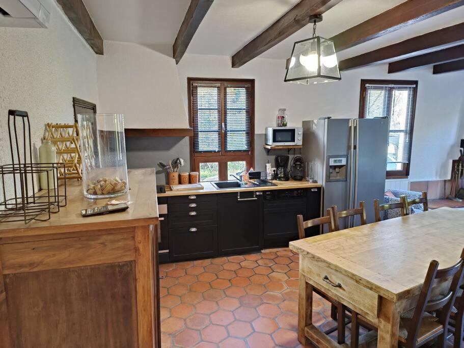 a large kitchen with a table and a refrigerator at Maison de vacances à la campagne in Boisset
