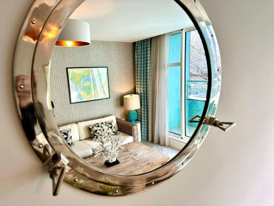 a mirror reflecting a living room with a couch at Stunning 2 bedroom Apartment inc Free Parking - 1 Minute walk to Poole Quay - Great Location - Free Parking - Fast WiFi - Smart TV - Newly decorated - sleeps up to 4 - Close to Poole & Bournemouth & Sandbanks in Poole