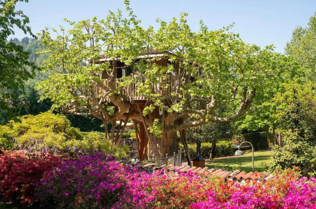 a tree house in a garden with flowers at Lake Como Dream Tree House in Como
