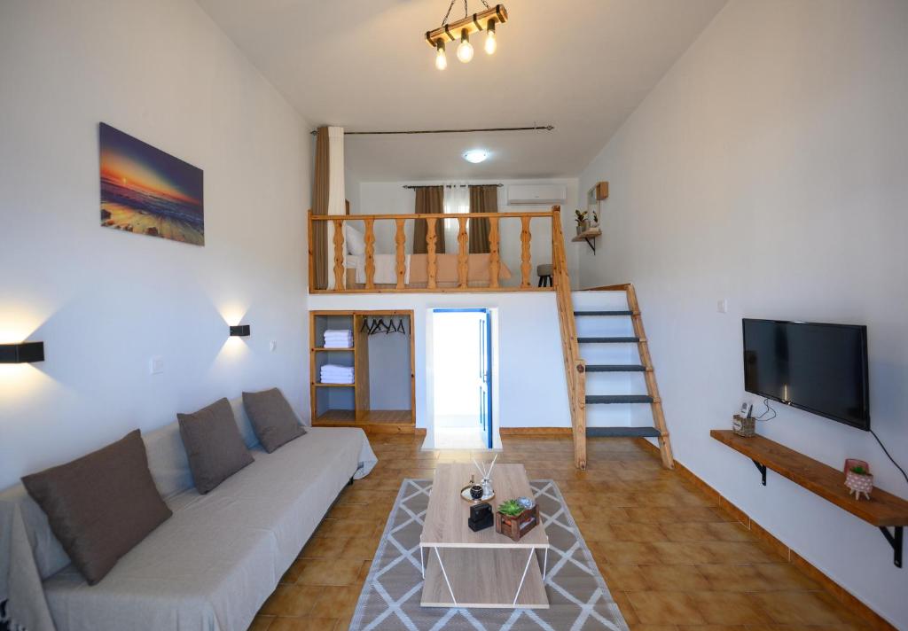 a living room with a couch and a tv at Verano Apartments in Kalymnos