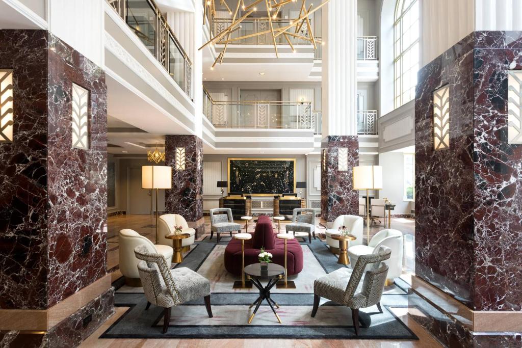 a lobby with couches and chairs and a fireplace at Hotel LeVeque, Autograph Collection in Columbus