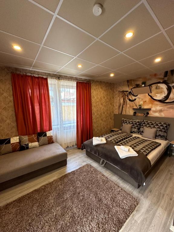 sypialnia z 2 łóżkami i czerwonymi zasłonami w obiekcie Demizson Vendégház w Tokaju