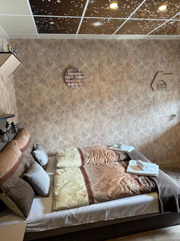 A bed or beds in a room at Demizson Vendégház