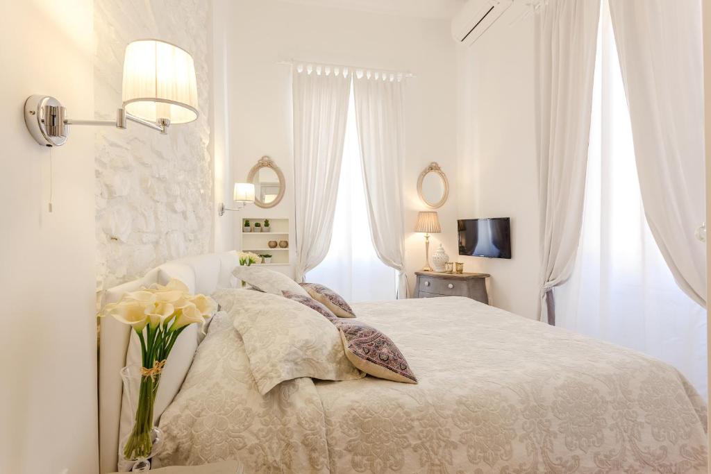 ローマにあるLa Casa Di Teoの白いベッドルーム(ベッド1台、花瓶付)