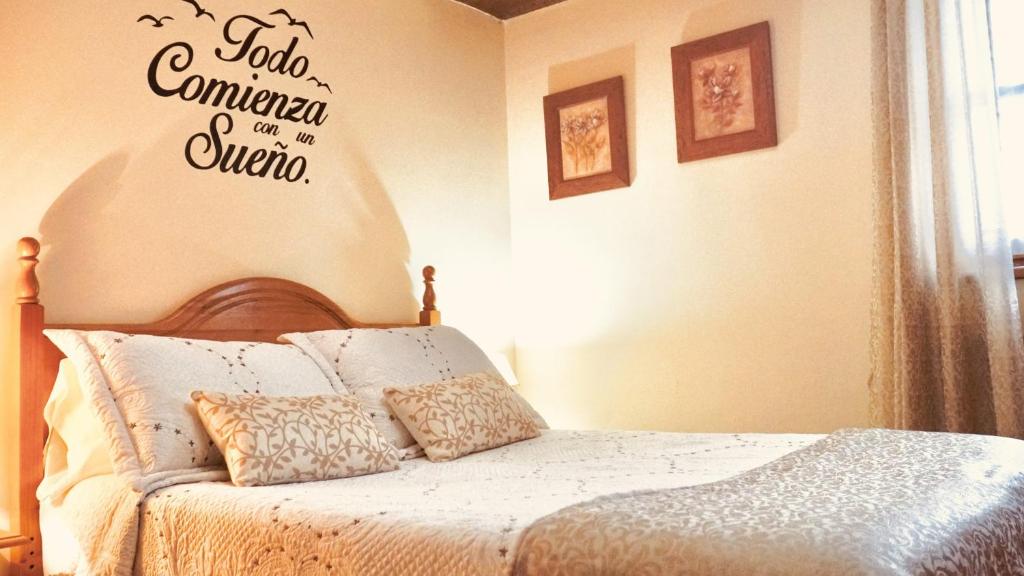 a bedroom with a bed with a sign on the wall at Apartamentos Caloca in Caloca