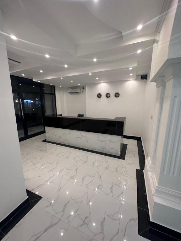 un vestíbulo con suelo de mármol y paredes blancas en Hôtel rotana en Brazzaville