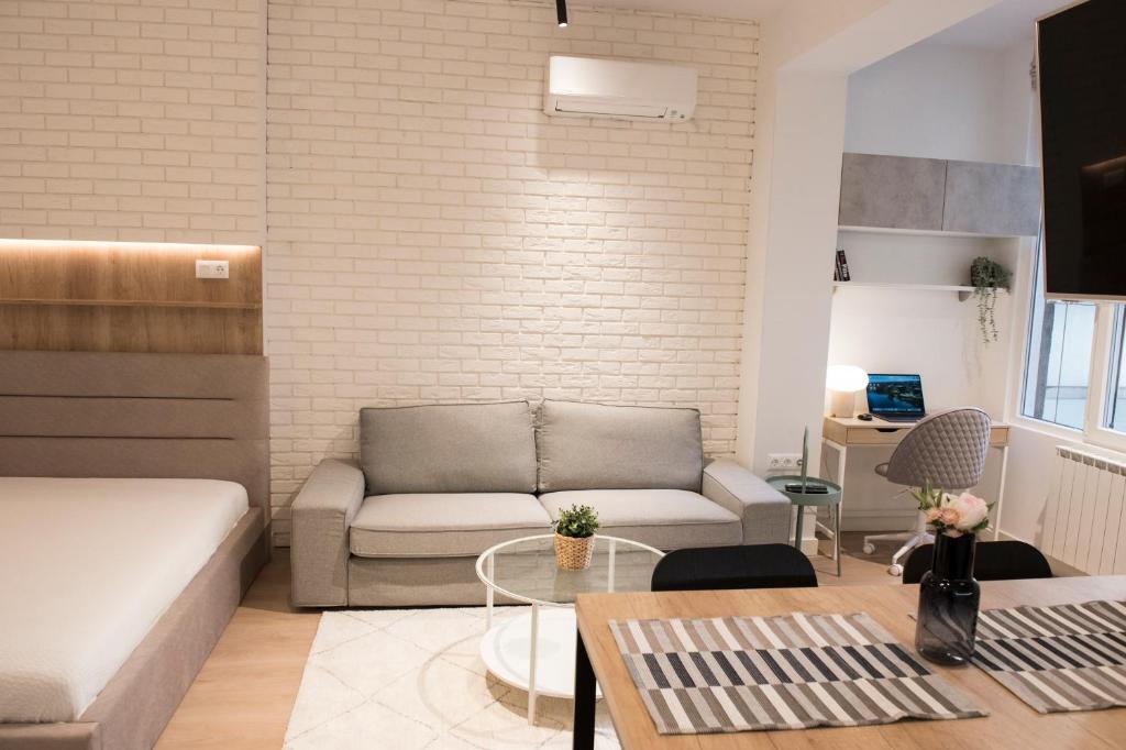 un soggiorno con divano e tavolo di Top Center Designer Studio Apartment a Sofia