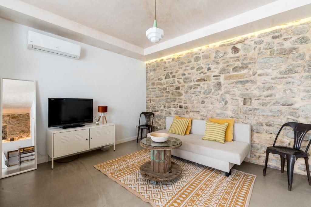 sala de estar con sofá blanco y pared de piedra en Erizo 4 Estudio en el Centro Histórico, en Tarifa