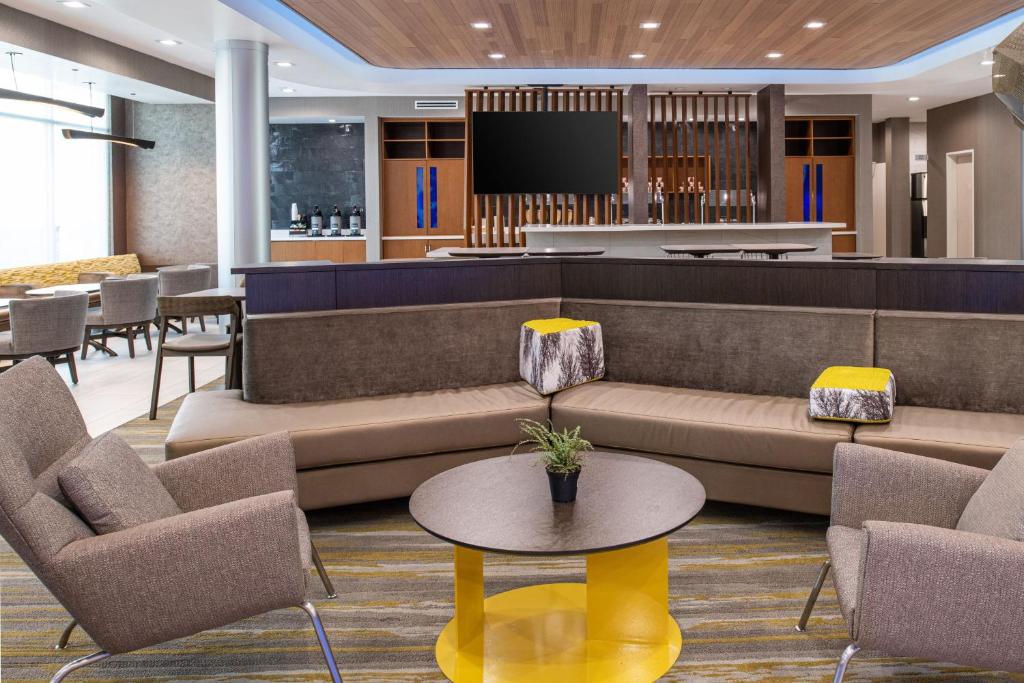 a lobby with a couch and chairs and a tv at SpringHill Suites by Marriott Riverside Redlands in Redlands