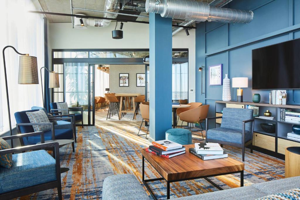 a living room with blue chairs and a table at Residence Inn by Marriott Slough in Slough