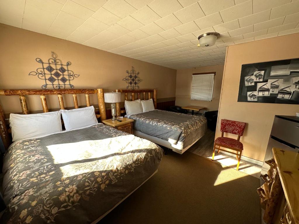 NipigonPinecrest Motel的酒店客房,配有两张床和椅子