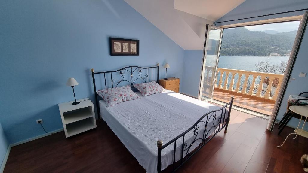 a bedroom with a large bed and a balcony at Vila Lukić in Slano